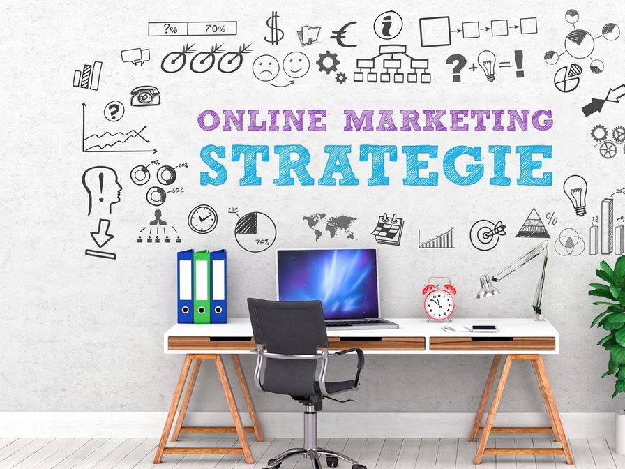 Schreibtisch mit Laptop vor einer Wand voller gezeichneter Marketing-Symbole und dem Schriftzug „Online Marketing Strategie“